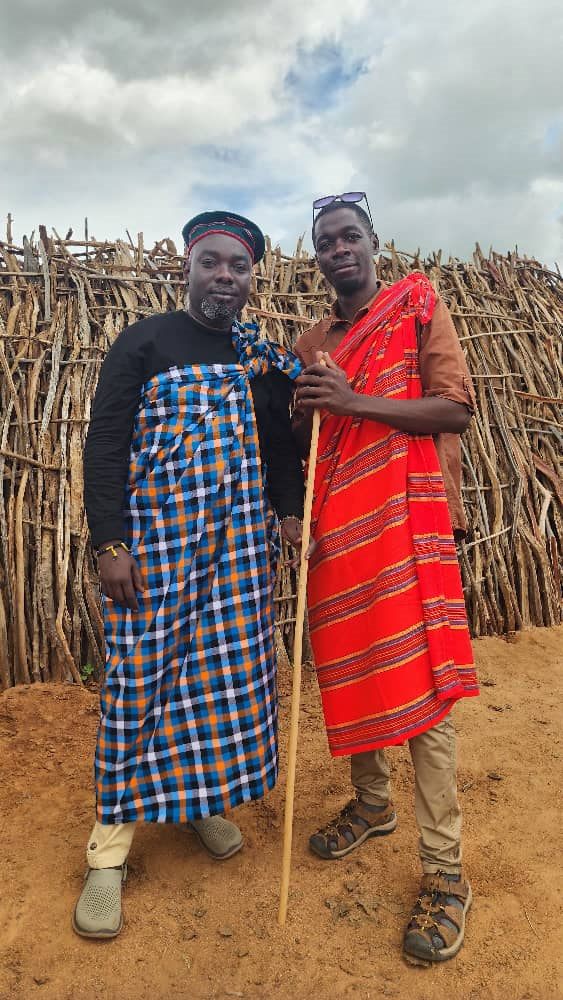 Paius with a community host in traditional wear
