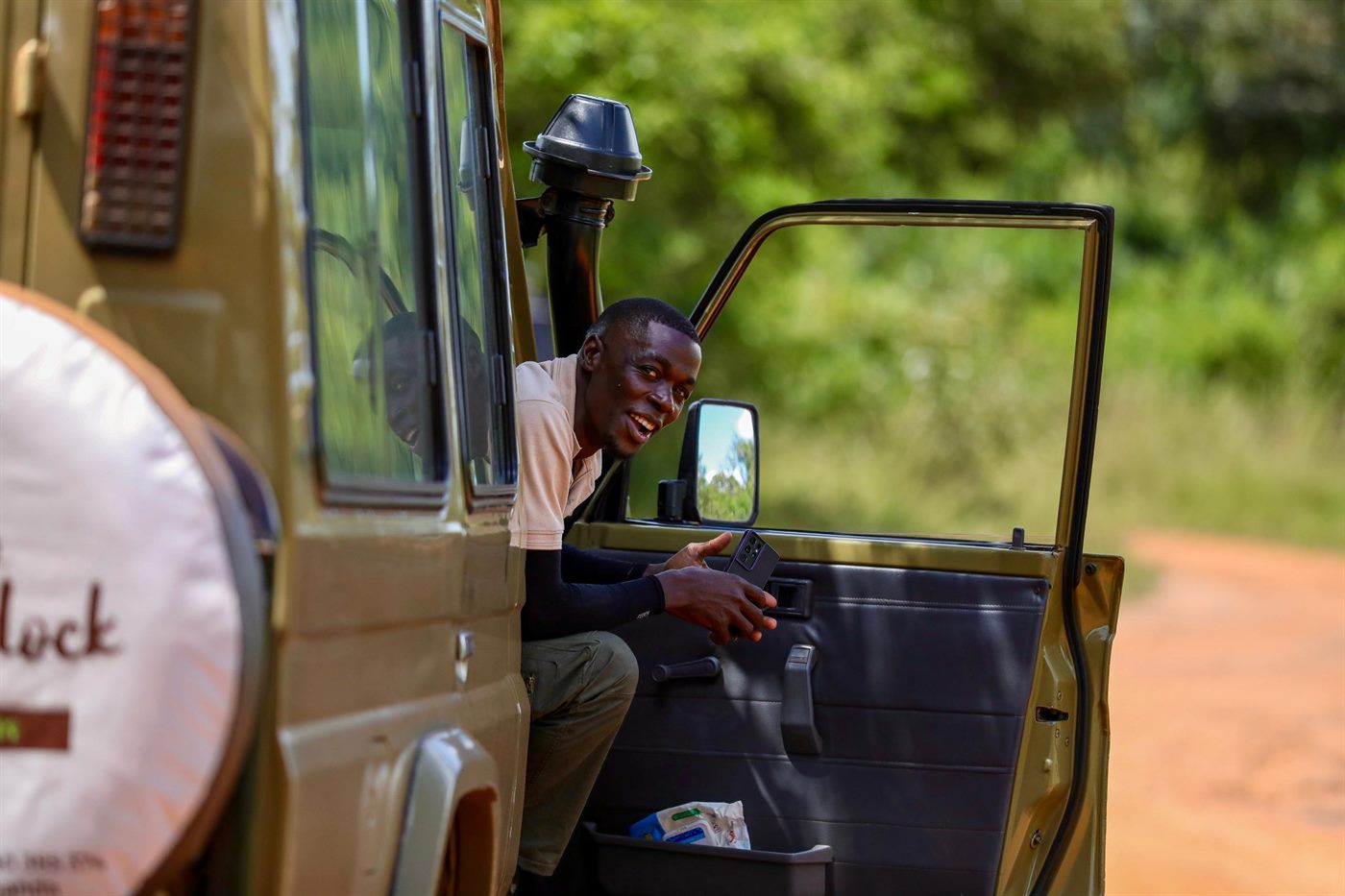 Paius smiling from a safari vehicle door