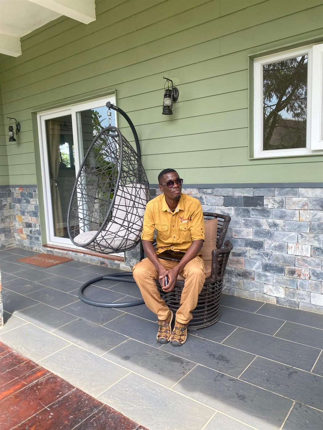 Paius seated at a lodge veranda