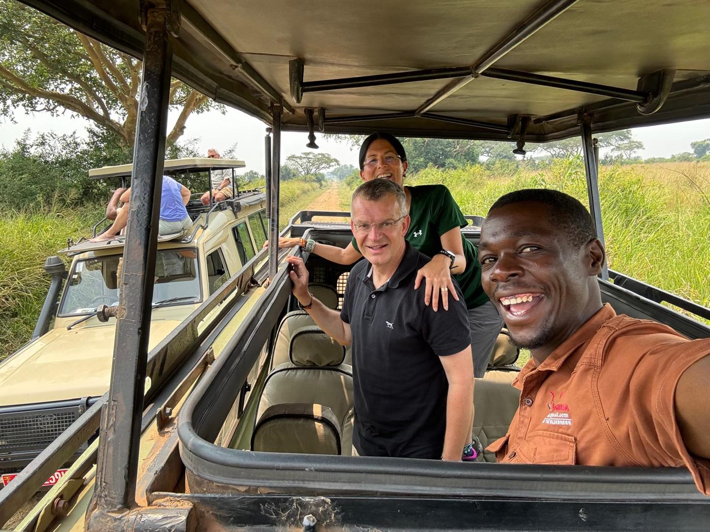Paius and guests smiling inside a safari vehicle