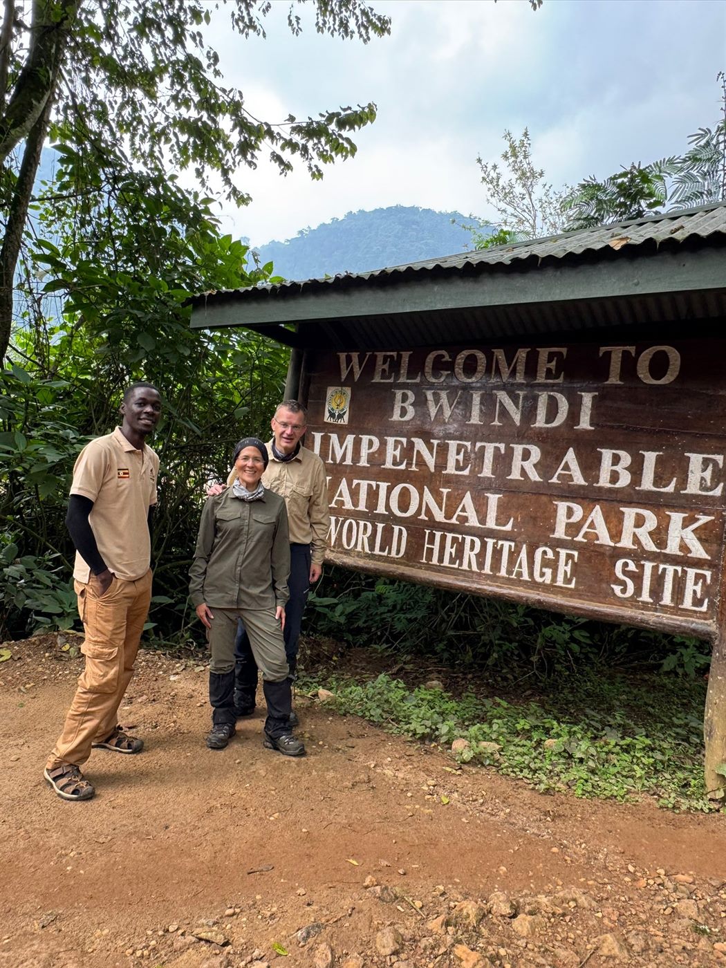 Paius and guests at Bwindi Impenetrable National Park sign