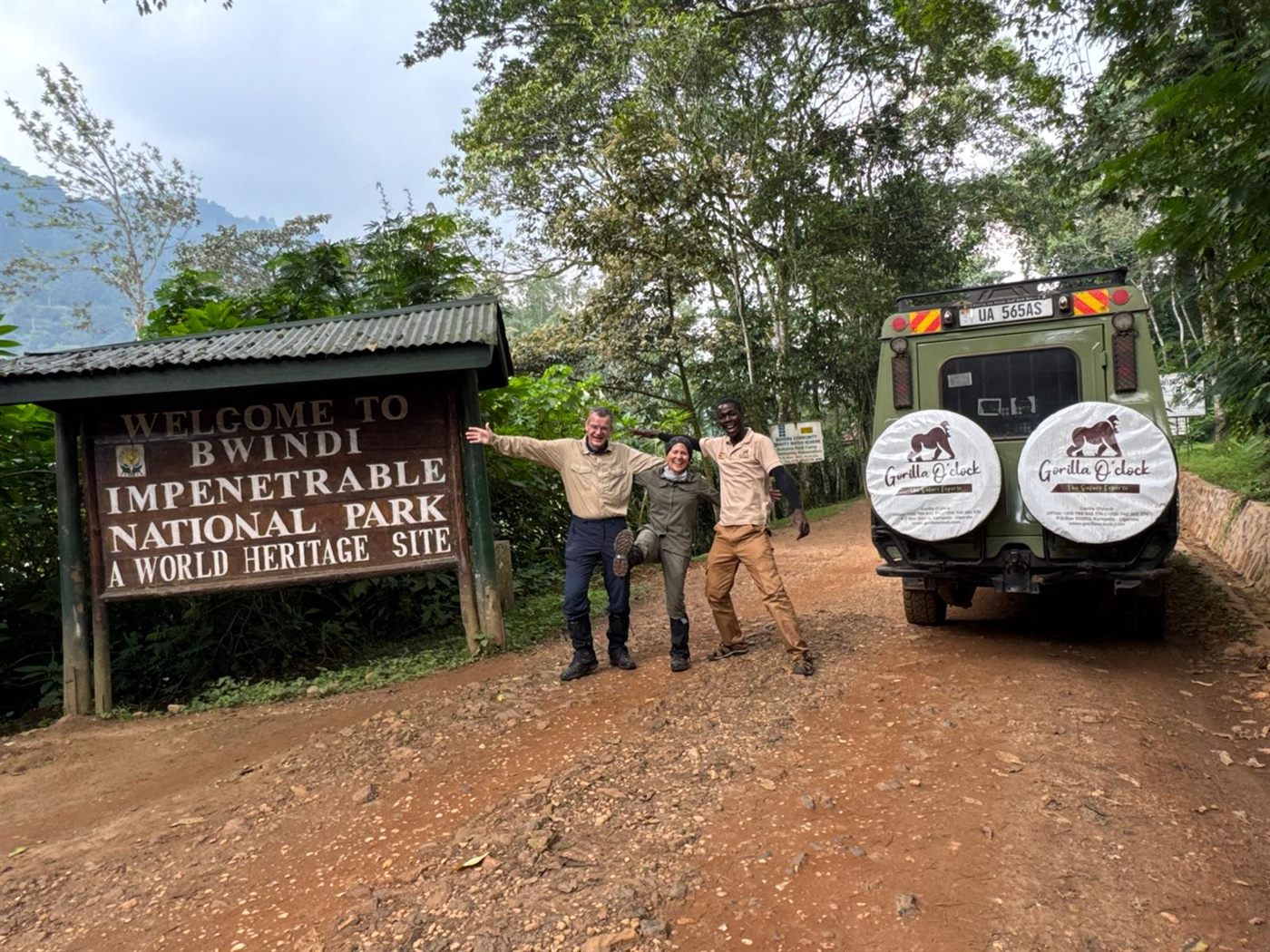 Paius and guests near a safari vehicle at Bwindi